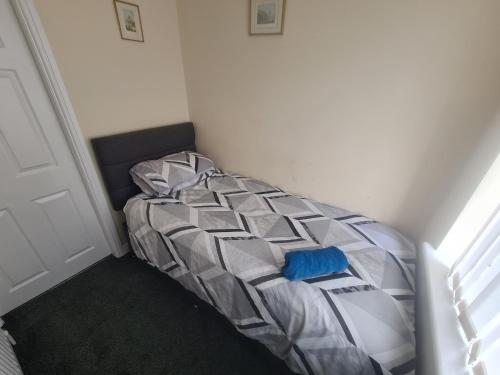 a bed in a corner of a room at L & J Escapes - 8 Bedrooms suitable for Contractors and Families- Private parking available for 6 vehicles in Coseley