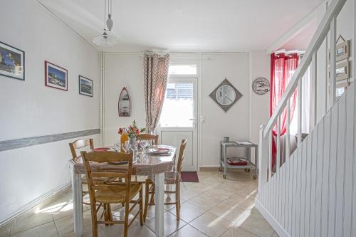 une salle à manger avec une table et des chaises dans l'établissement La Maison du Pêcheur, à Étretat