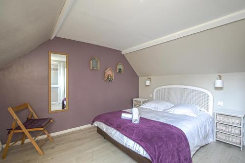 une chambre avec un grand lit avec une couverture violette dans l'établissement La Maison du Pêcheur, à Étretat