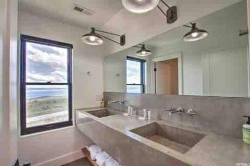 Skybridge Bear Lake Sleeps 61-75 with condo add-on في Fish Haven: حمام به مغسلتين ومرآة كبيرة