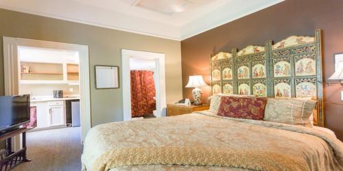 a bedroom with a large bed and a flat screen tv at Panama Hotel and Suites in San Rafael