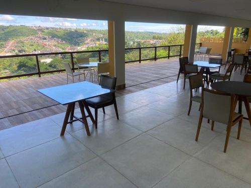 um restaurante com mesas e cadeiras e uma varanda em Flat dos Sonhos Bananeiras em Bananeiras