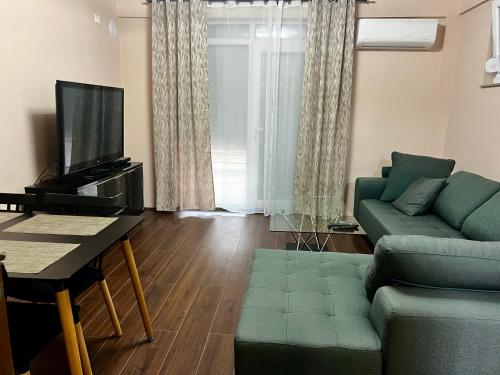 a living room with a couch and a tv at Juliya Apartment in Kavadarci