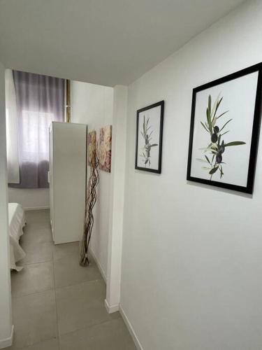 una camera con frigorifero e quadri appesi al muro di Loft Alby 10 ristrutturato nuovo a Torino