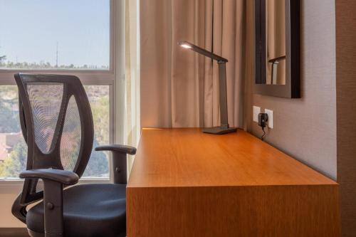 a desk with a chair next to a window at Hilton Garden Inn Neuquen in Neuquén