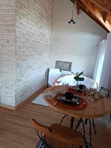 a dining room with a table and a brick wall at Pousada rota nas montanhas in Camanducaia