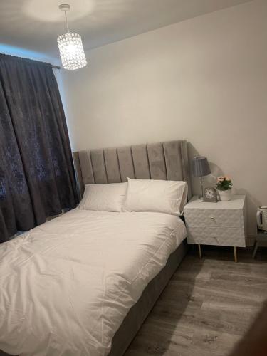 a large bed in a bedroom with a night stand at Divine Room in London