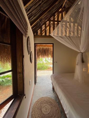 a bedroom with a bed and a large window at Tropical Cabins Curaçao in Dorp Sint Michiel