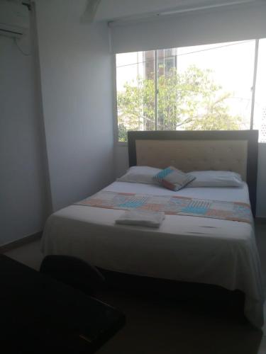 a bedroom with a large bed with a window at BOUTIQUE REAL in Barrancabermeja