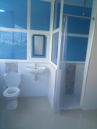 Baño azul con aseo y lavamanos en BOUTIQUE REAL, en Barrancabermeja