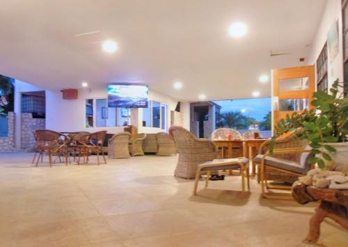 a living room with chairs and tables and a tv at Boca Simon Vacation Curacao in Willemstad