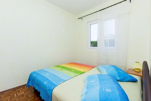 a small bedroom with a bed and a window at House Ivana Tribunj in Tribunj