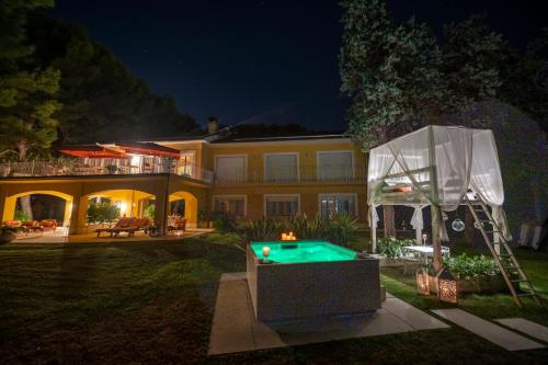 dom z basenem w ogrodzie w nocy w obiekcie Tra gli Alberi e il Mare w mieście Sirolo