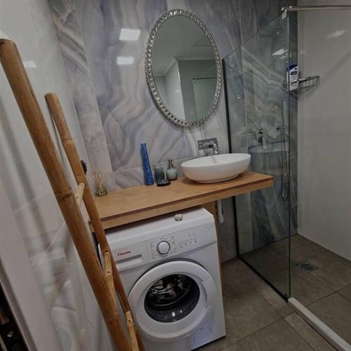 a bathroom with a washing machine and a sink at Farisma - Bright and central apt in Kalamata in Kalamata