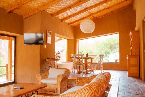 un soggiorno con TV, tavolo e sedie di Refugios La Frontera a Pisco Elqui