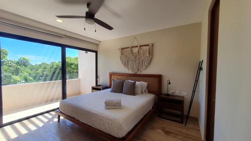 a bedroom with a bed and a large window at Luxury & Modern Apartments in Tulum Top Amenities By Yeah in Tulum