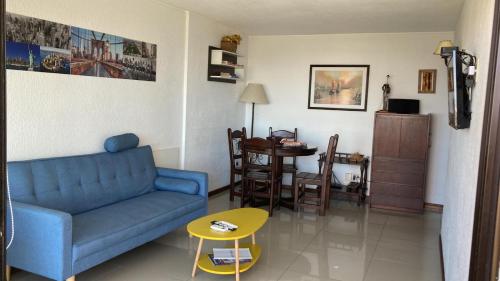 sala de estar con sofá azul y mesa en Apto con parrilla en balcón a 80 de la playa! Con wifi, en Punta del Este