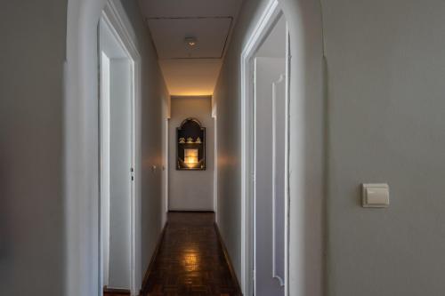 a hallway with two white doors and a long corridor at MàHouse GuestHouse in Lisbon