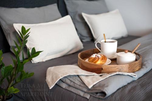 a tray of croissants and a cup of coffee on a bed at Teika No 1 Apartment in a quiet green area, self check-in in Rīga