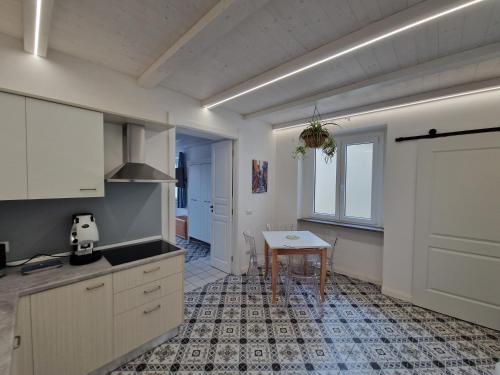 a kitchen with white cabinets and a table in it at Casa Vacanze Penelope in Pizzo