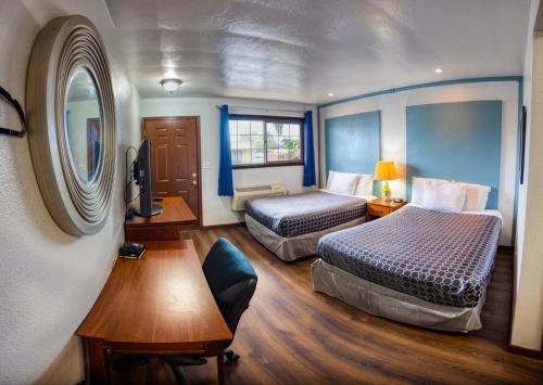 a hotel room with two beds and a mirror at Budget Inn in The Dalles