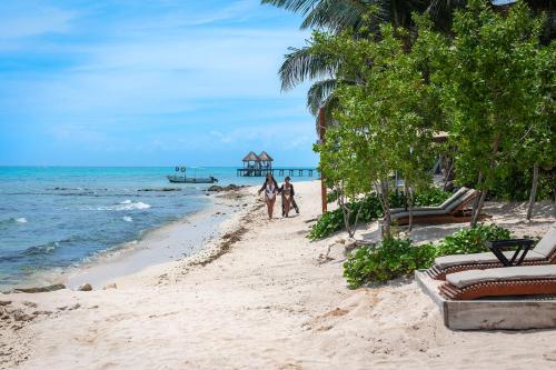 a group of people walking down a beach at Alea Tulum in Tulum