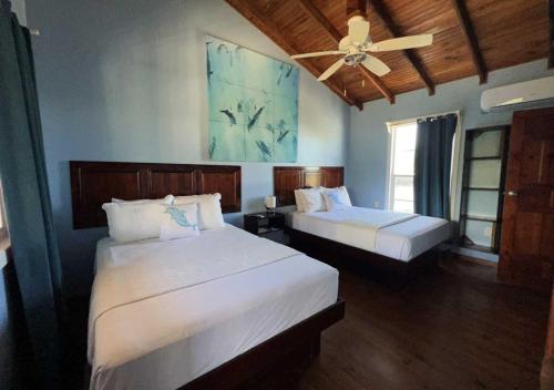 um quarto com 2 camas e uma ventoinha de tecto em Eastern Harbor Resort em Útila