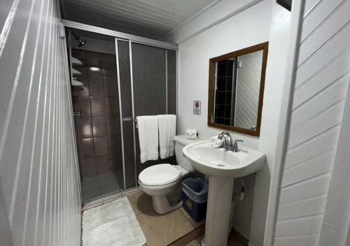 uma casa de banho com um WC, um lavatório e um chuveiro em Eastern Harbor Resort em Útila