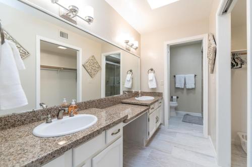 a bathroom with two sinks and a large mirror at A Few Steps To Heated Pool, Tennis, Bike Trail in Scottsdale