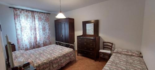 a bedroom with two beds and a dresser and a mirror at Agriturismo Saralisa in Montecarlo