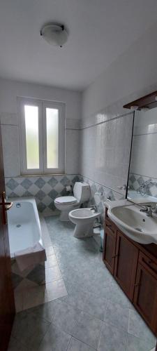 a bathroom with two sinks and a tub and two toilets at Agriturismo Saralisa in Montecarlo