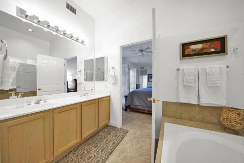 een badkamer met een bad, een wastafel en een spiegel bij Waterfront 1st Flr, Gated, 2 Bd Office, Trail in Scottsdale