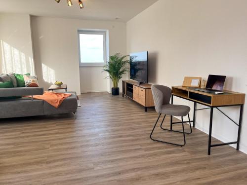 a living room with a couch and a table with a laptop at Home Inn Apartments - 202 in Minden
