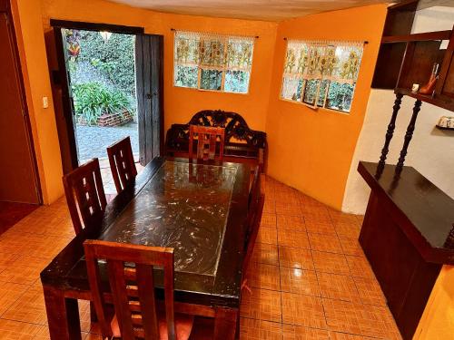 comedor con mesa, sillas y ventana en BUNGALOWS ANDREA, en Tepoztlán