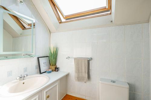 bagno con lavandino, servizi igienici e lucernario. di The Cheeseloft - Spacious one bed with terrace a Kirkcudbright