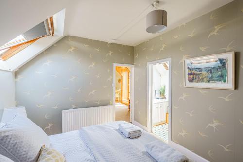 a small bedroom with a bed and a staircase at The Cheeseloft - Spacious one bed with terrace in Kirkcudbright