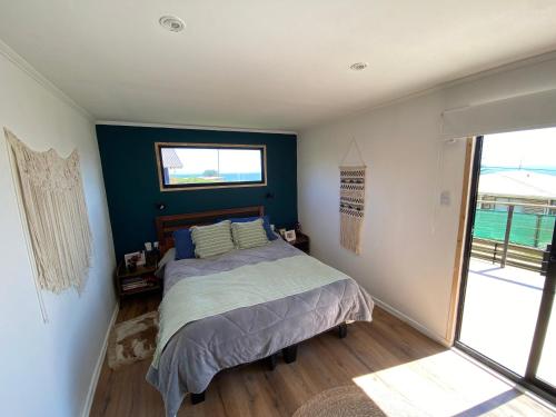 - une chambre avec un lit et une grande fenêtre dans l'établissement Viewcasavieja, à Pelluhue