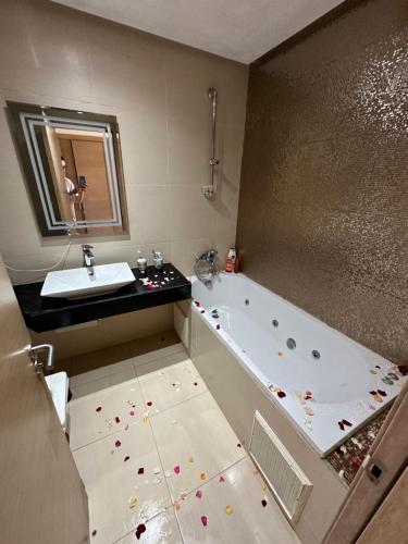 a bathroom with a bath tub and a sink at OCEAN VIEW, Prestigia Plage des Nations in Sidi Bouqnadel