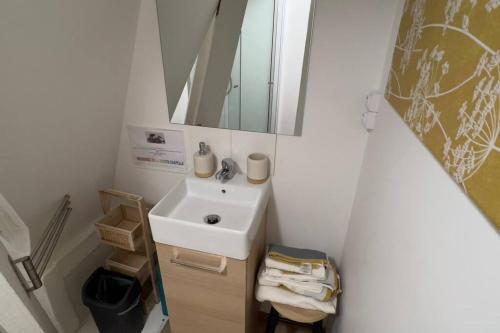 une petite salle de bain avec un lavabo et un miroir dans l'établissement Studio SUN - Hyper Centre Dunkerque & Proche Plage '15m, à Dunkerque