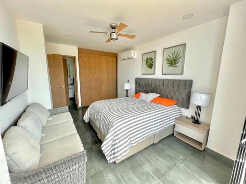 a bedroom with a bed and a couch at Boca de cielo 504 / Vista al mar in Mazatlán