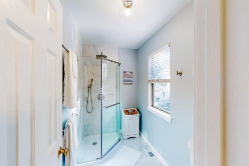 a bathroom with a glass shower stall and a window at Anchors Away Abode in Annapolis