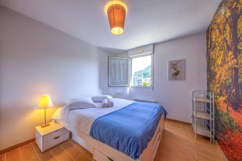 a bedroom with a blue bed and a window at L'Espace Détente - GEM / GARE in Grenoble