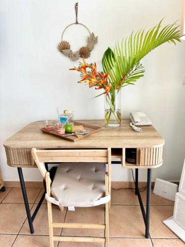 a wooden desk with a vase of flowers at Studio dans un magnifique complexe de vacances a ST luce in Sainte-Luce