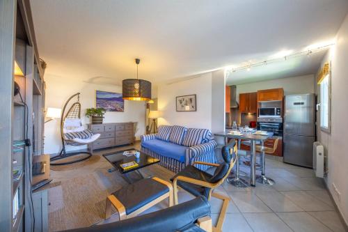 un salon avec un canapé bleu et une cuisine dans l'établissement L'Espace Détente - GEM / GARE, à Grenoble