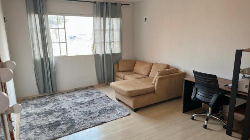 a living room with a couch and a chair and a desk at Não disponível mais in Campo Grande