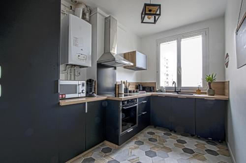 une cuisine avec un évier et une cuisinière four supérieur dans l'établissement L'Escapade Océane, appartement avec parking, au Havre