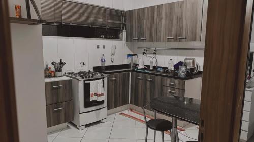 a kitchen with wooden cabinets and a stove top oven at Não disponível mais in Campo Grande