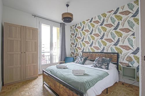 - une chambre avec un grand lit et un mur coloré dans l'établissement L'Escapade Océane, appartement avec parking, au Havre