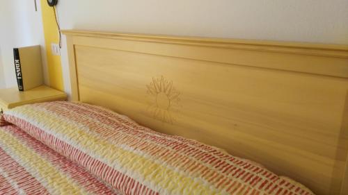 a bed with a wooden headboard in a room at B&b Sa Zodia Guest House in Bitti
