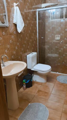 a bathroom with a toilet and a sink and a shower at Não disponível mais in Campo Grande